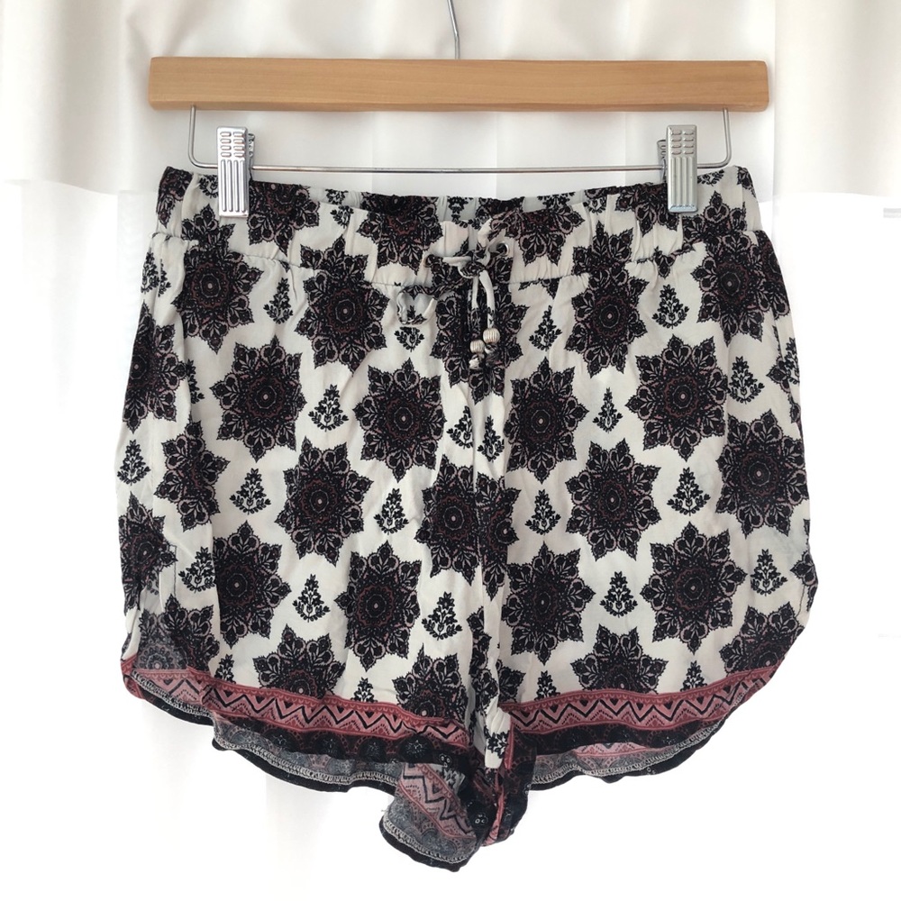 White flowy shorts with reddish floral pattern